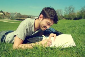 Homme qui écrit sur l'herbe
